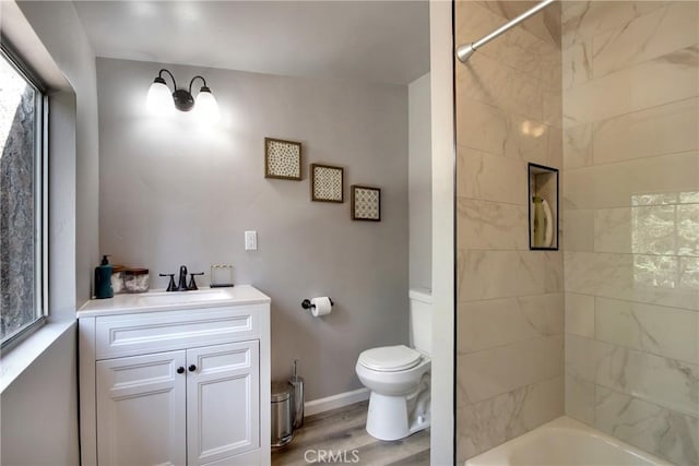 full bathroom featuring vanity, hardwood / wood-style flooring, toilet, and tiled shower / bath