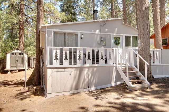 rear view of house with a storage shed