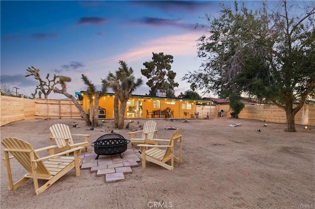 yard at dusk with a patio and an outdoor fire pit