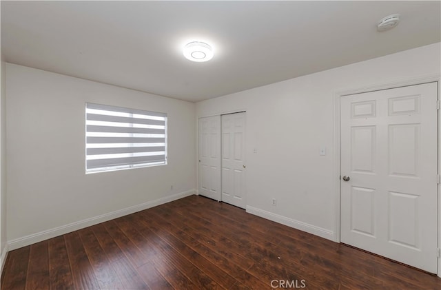 unfurnished bedroom with a closet and dark hardwood / wood-style flooring