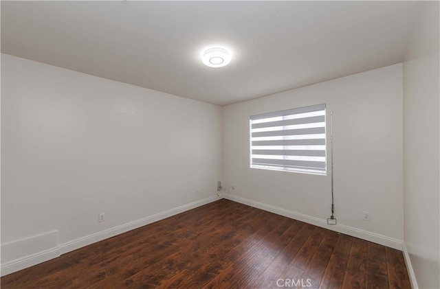 unfurnished room with dark wood-type flooring