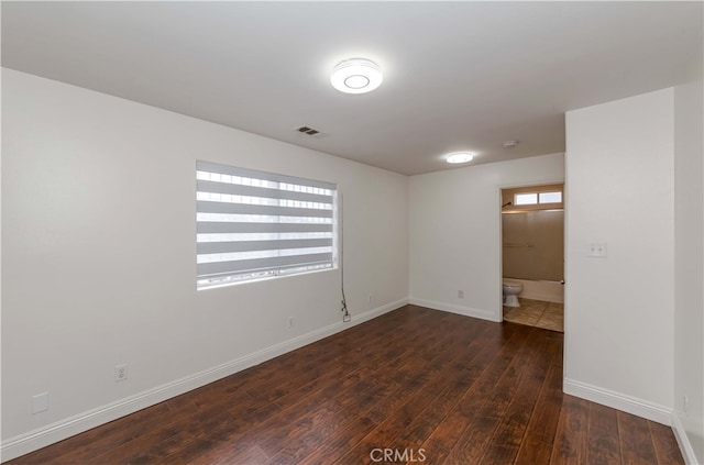 unfurnished room with dark wood-type flooring