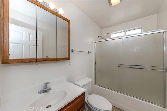 full bathroom featuring vanity, toilet, and bath / shower combo with glass door