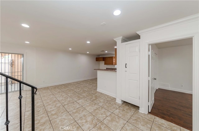 spare room featuring crown molding and light wood-type flooring