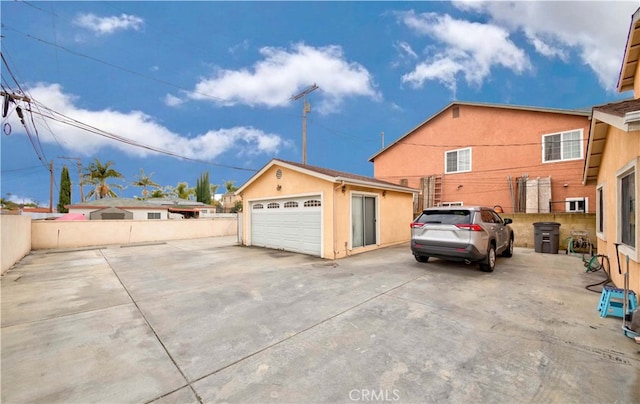 view of front of home with a garage and an outbuilding