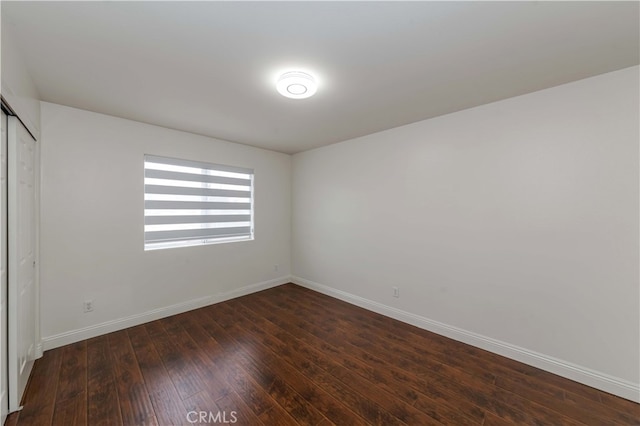 empty room with dark hardwood / wood-style flooring