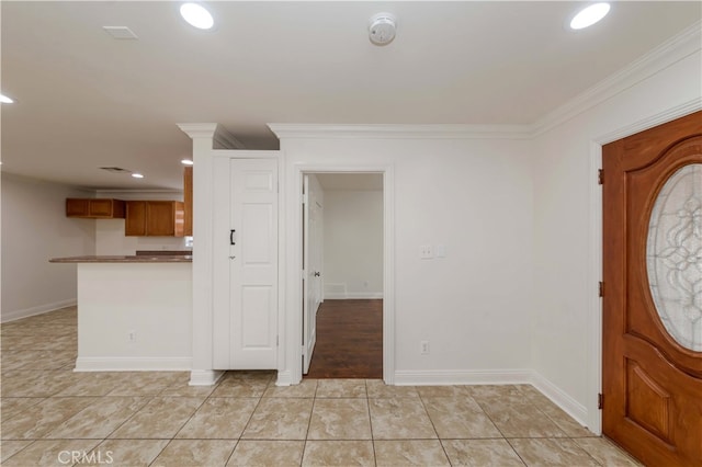 entryway featuring crown molding and light tile patterned flooring