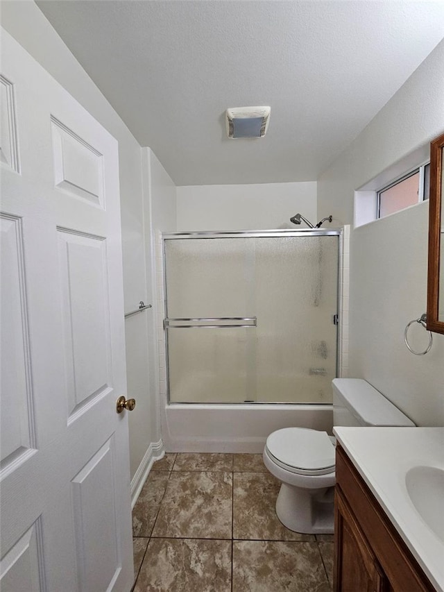 full bathroom with bath / shower combo with glass door, a textured ceiling, toilet, vanity, and tile patterned flooring