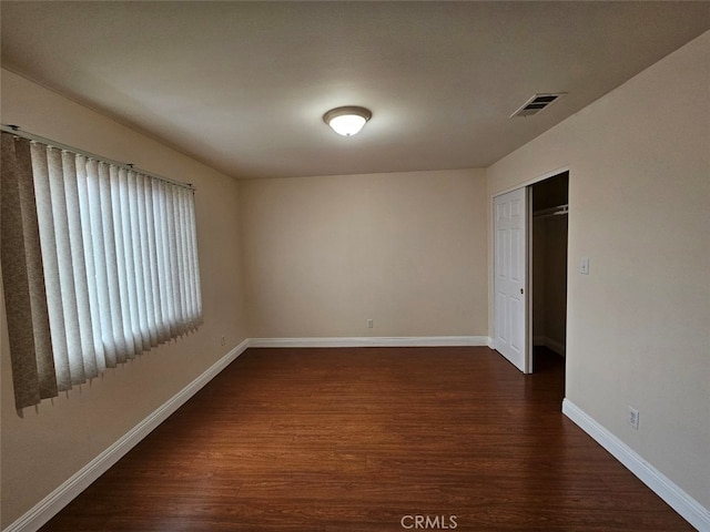 unfurnished room with dark hardwood / wood-style flooring