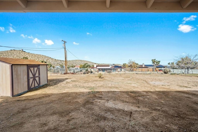 view of yard with a mountain view and a storage unit