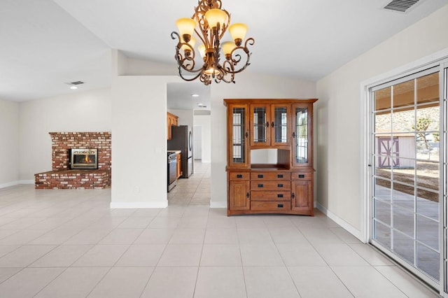 unfurnished dining area with a notable chandelier, lofted ceiling, and light tile patterned floors