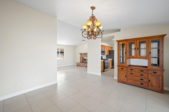 interior space with a notable chandelier, lofted ceiling, a fireplace, and light tile patterned floors