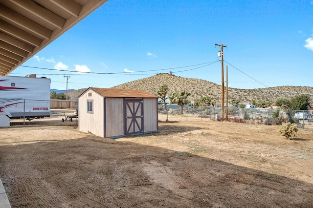 view of yard featuring a mountain view and a storage unit