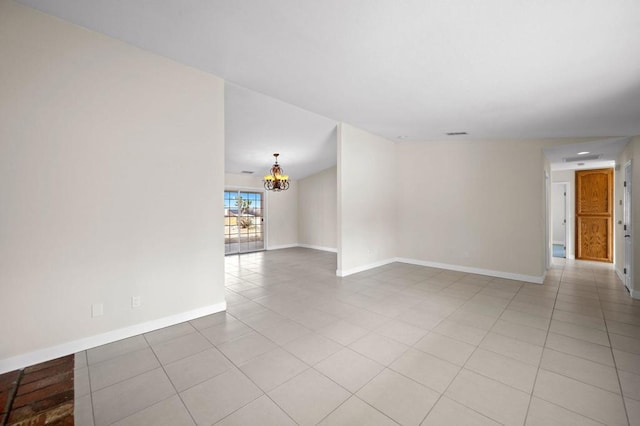 empty room featuring an inviting chandelier and light tile patterned flooring