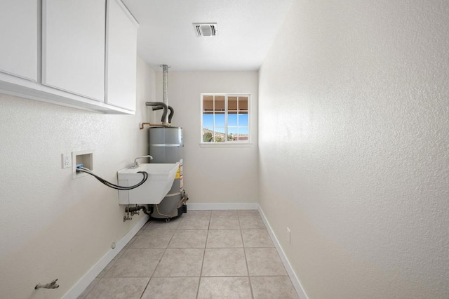 clothes washing area featuring secured water heater, cabinets, sink, washer hookup, and light tile patterned flooring