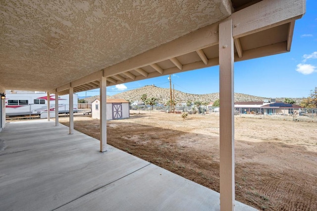 view of patio with a mountain view and a storage unit