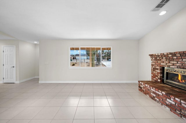 unfurnished living room with a fireplace and light tile patterned floors