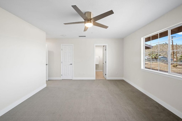 unfurnished room featuring light carpet and ceiling fan