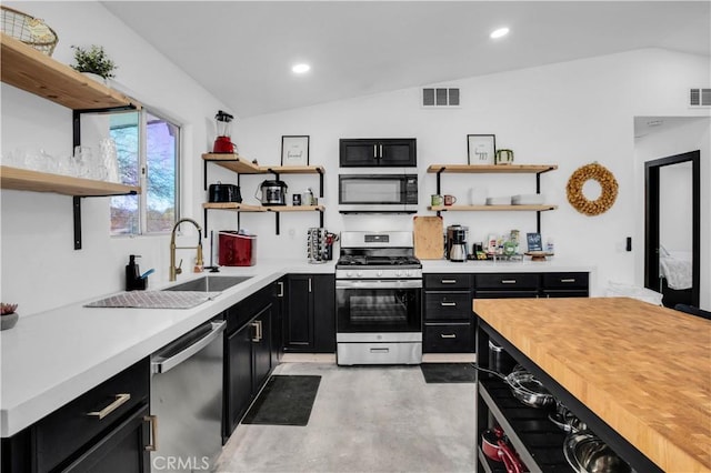 kitchen featuring stainless steel appliances, lofted ceiling, and butcher block counters