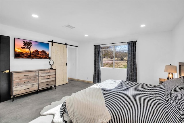 bedroom featuring concrete floors and a barn door