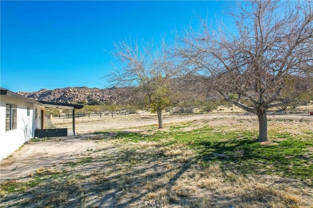 view of yard featuring a patio, a rural view, and a mountain view