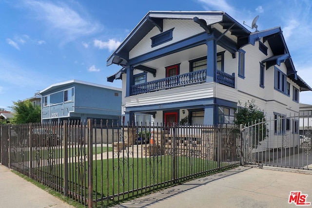 view of front of property featuring a balcony and a front yard