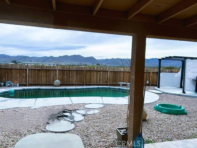 view of pool featuring a mountain view and a patio area