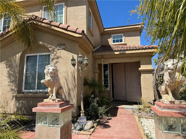 4810 Swallowtail Rd, Hemet, CA 92545 - view of exterior entry with stucco siding and a tiled roof
