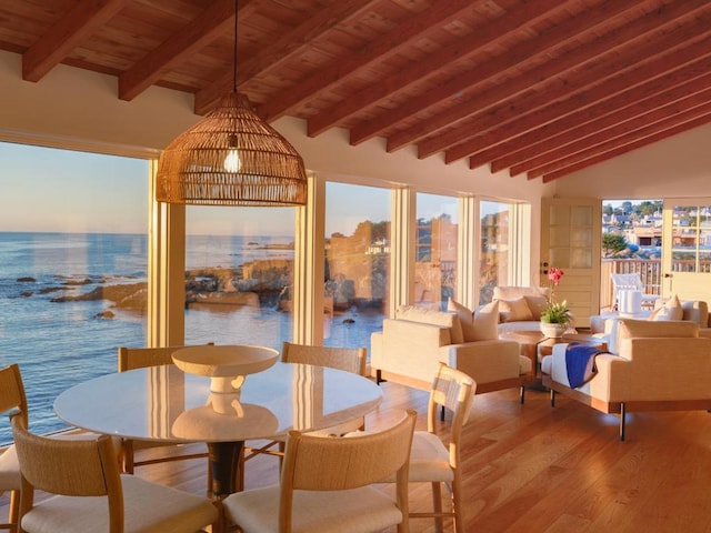 sunroom featuring wood ceiling, lofted ceiling with beams, and a water view