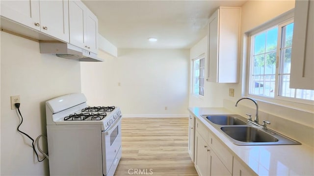 kitchen featuring sink, white cabinets, white range with gas stovetop, and light wood-type flooring