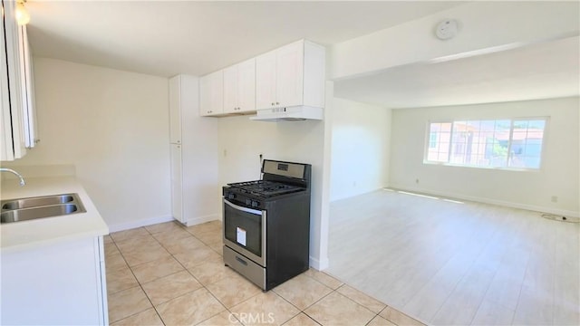 kitchen featuring white cabinets, gas stove, light wood-type flooring, and sink