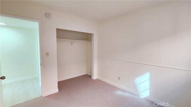 unfurnished bedroom with a closet and carpet floors