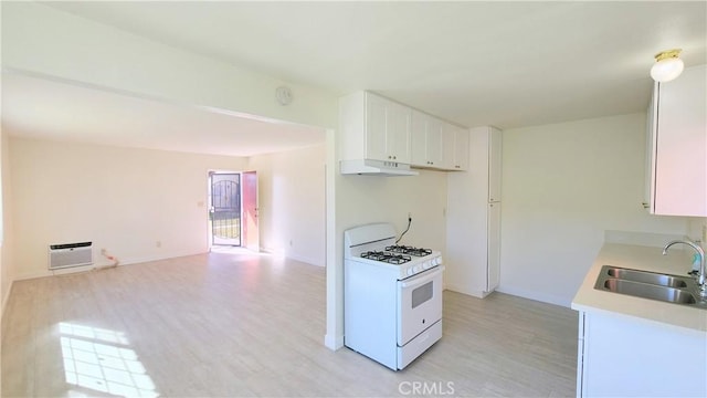 kitchen with sink, white cabinets, light hardwood / wood-style flooring, and white gas range oven