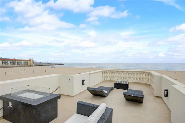 view of patio featuring a water view and a beach view