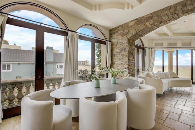 dining room featuring french doors, beamed ceiling, and a wealth of natural light