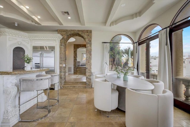 dining space featuring beamed ceiling