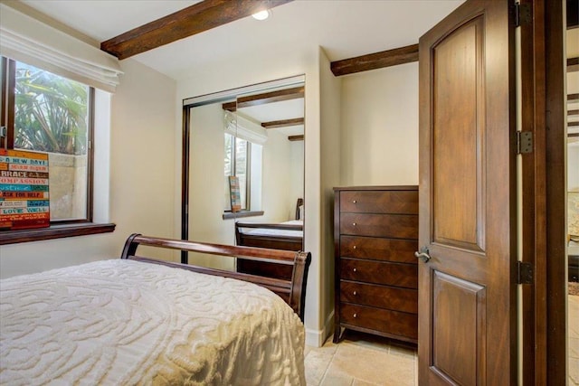 bedroom with a closet, beam ceiling, and multiple windows