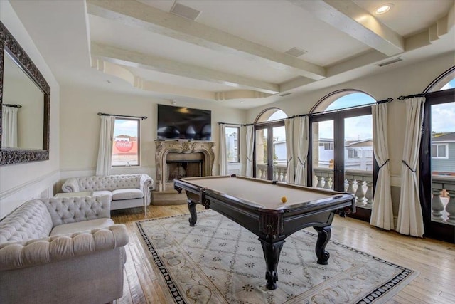 rec room featuring beam ceiling, a premium fireplace, pool table, and hardwood / wood-style flooring