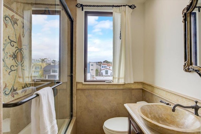 full bathroom with vanity, shower / tub combination, toilet, and tile walls