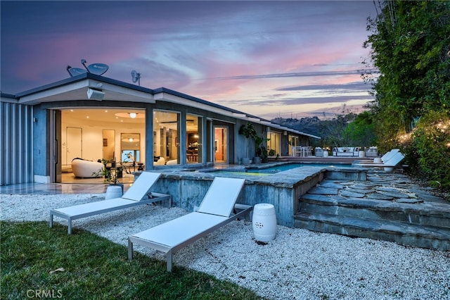 back house at dusk with a patio area