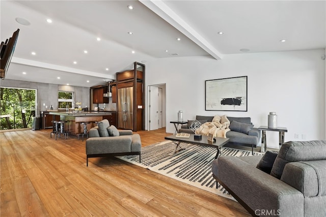 living room with light wood-type flooring and beam ceiling