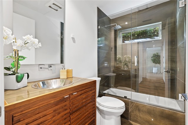 full bathroom featuring toilet, enclosed tub / shower combo, and vanity