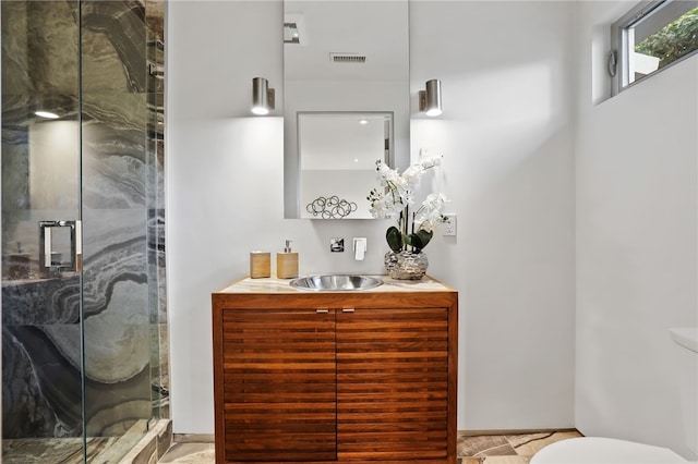 bathroom with an enclosed shower, vanity, and toilet