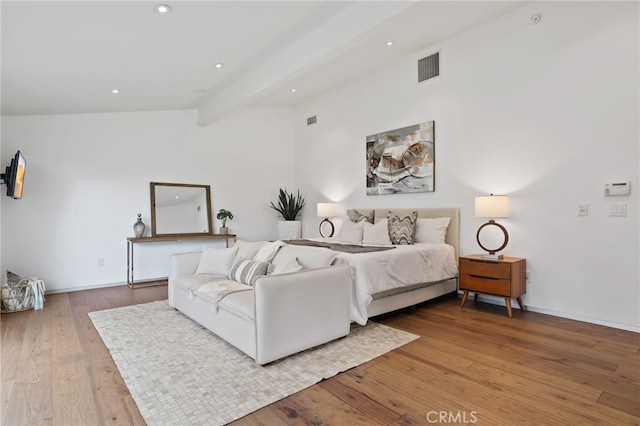 bedroom with light hardwood / wood-style floors and lofted ceiling with beams