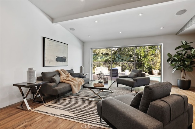 living room featuring vaulted ceiling with beams and hardwood / wood-style floors