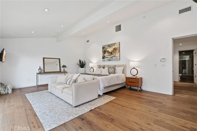 bedroom featuring lofted ceiling with beams and light wood-type flooring