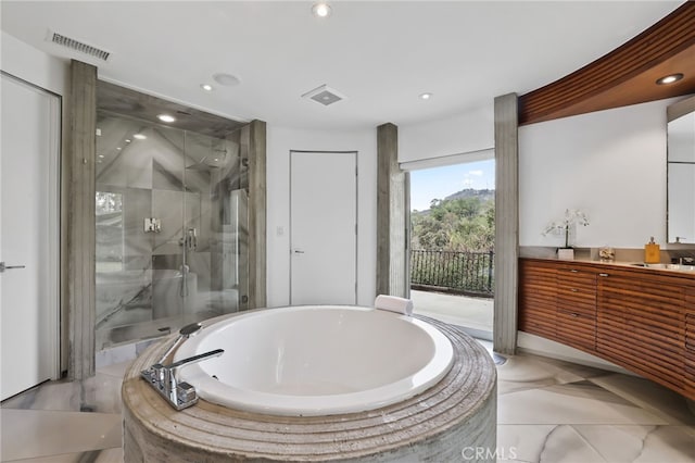 bathroom featuring vanity and separate shower and tub