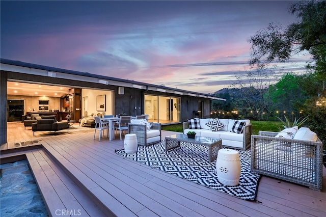 deck at dusk featuring outdoor lounge area