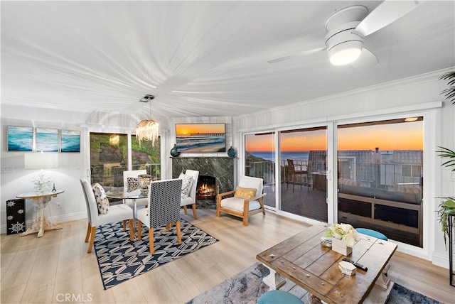 sunroom / solarium with a fireplace and ceiling fan