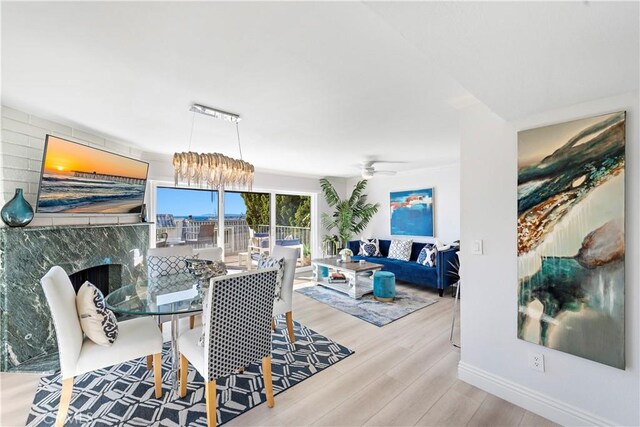 dining space with ceiling fan with notable chandelier and light wood-type flooring